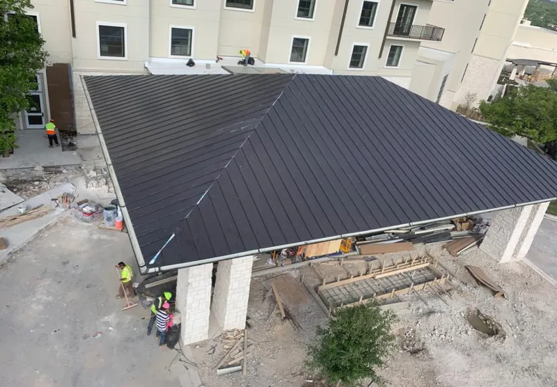 Metal roofing installation team working on a commercial building in Versailles